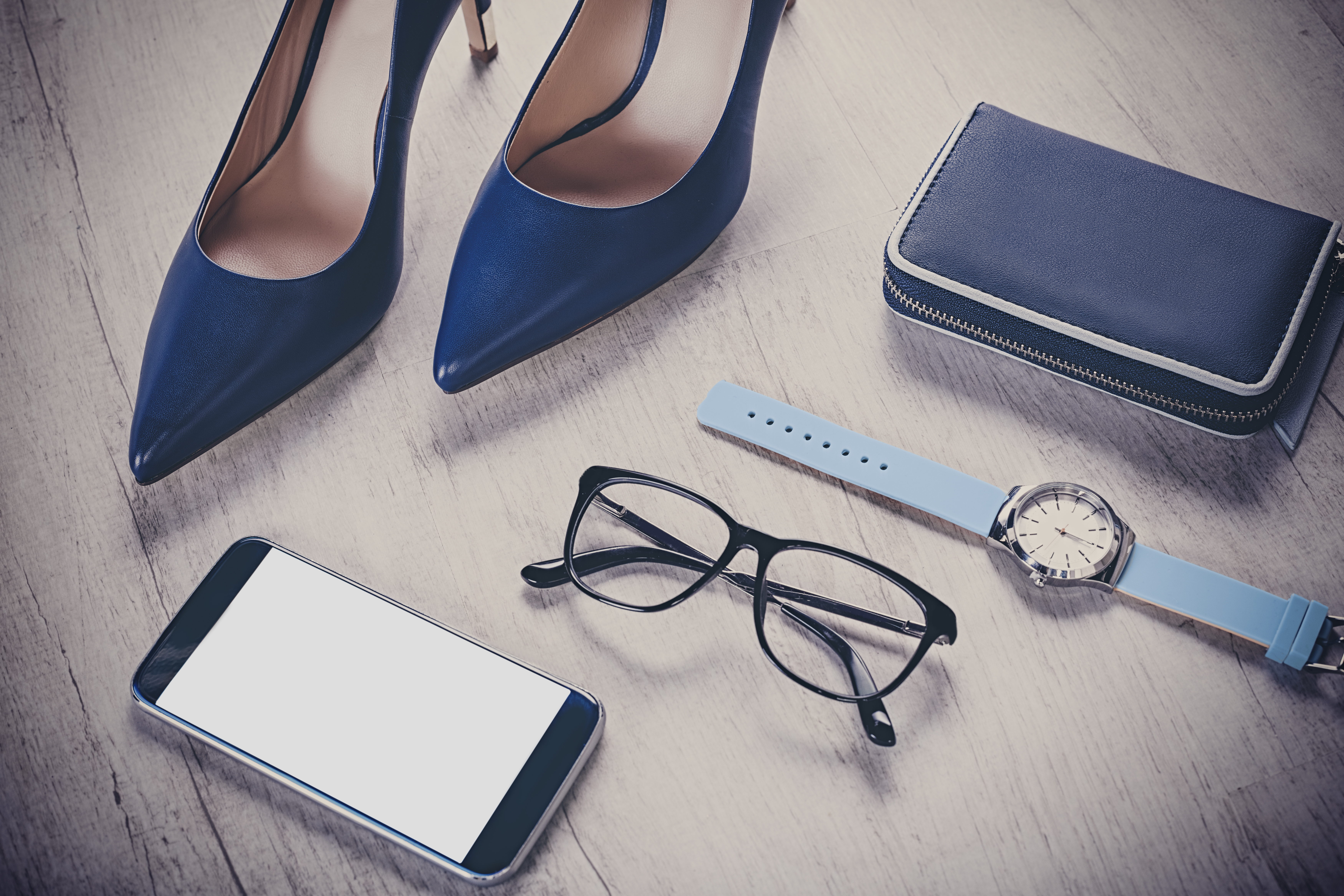 Stillettsko, mobil, briller, klokke og lommebok på gulvet