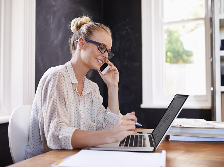 Kvinne i telefon noterer på PC